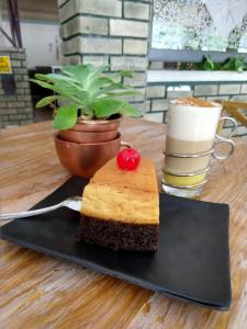 un trozo de pastel en un plato negro en una mesa en Hotel Raldos Inn, en Salamanca