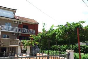 a building with a fence in front of a house at Apartments Lord in Trebinje