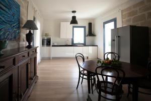 una cucina con tavolo, sedie e frigorifero di Luxury Favignana Villa a Favignana