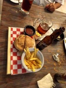 a table with a sandwich and french fries and drinks at Hotel Raldos Inn in Salamanca