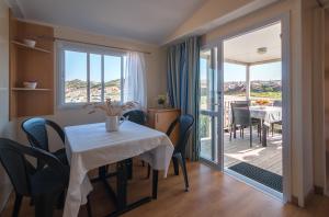 a dining room with a table and a balcony at Abbatoggia Village in La Maddalena