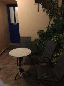 a table and chairs in a room with a door at Eugenia travasarou sea view appartments in Diakofti