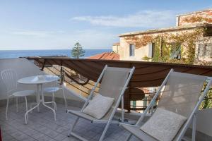 patio z krzesłami i stołem na balkonie w obiekcie Koral house w mieście Alghero