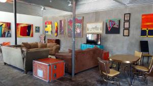een woonkamer met banken, tafels en schilderijen bij Pelican Spa in Truth or Consequences