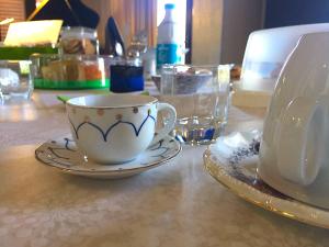 un tavolo con una tazza di tè e piatti sopra di Alex Room Airport a Elmas