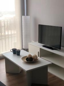 uma mesa branca com uma televisão e um prato de comida em Apartaments L`Ametller em Cervera