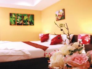 a bed with flowers on top of it at The Great Residence Hotel in Lat Krabang