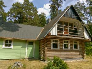 una cabaña de madera con techo de gambrel en Nature Guest House en Võsu