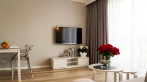 a living room with a table and a tv on the wall at Apartament Olimp in Gorzów Wielkopolski