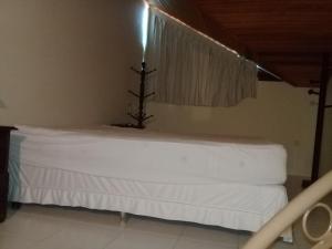 a bedroom with a white bed with a tree on it at Flat Monte Castelo em Gravata PE in Gravatá +19 photos