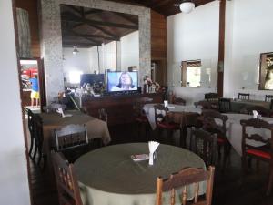 a restaurant with tables and chairs and a tv in the background at Flat Monte Castelo em Gravata PE in Gravatá