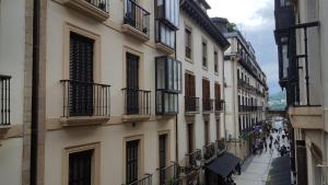 a city street with buildings and people walking on the sidewalk at Pension Kaia in San Sebastián