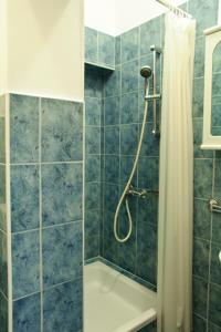 W wyłożonej niebieskimi kafelkami łazience znajduje się prysznic i wanna. w obiekcie Apartmani Blaslov w mieście Kali +37 zdjęć