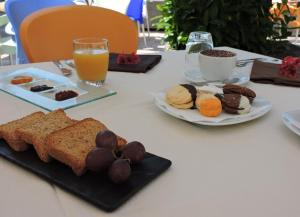 - une table avec une assiette de produits pour le petit-déjeuner et du jus d'orange dans l'établissement Cilentorooms Paestum, à Paestum