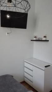 a white bedroom with a bed and a desk at Anna in Krynica Zdrój