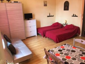 1 Schlafzimmer mit 2 Betten, einem Tisch und einem Stuhl in der Unterkunft Residence Le Continental in Vittel