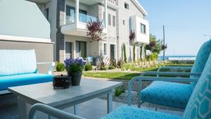 a patio with blue chairs and a table and a building at Costa Domus Blue Luxury Apartments in Nikiti