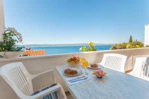 a table with plates of food and drinks on a balcony at Miran apartments Pisak in Pisak
