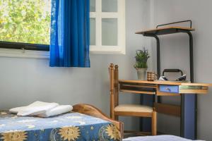 a bedroom with a desk and a bed and a window at Apartment Voula Myrtos in Anomeriá