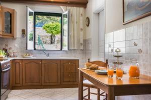 a kitchen with a wooden table with two glasses of orange juice at Apartment Voula Myrtos in Anomeriá