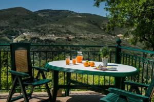 a table with oranges and drinks on a balcony at Apartment Voula Myrtos in Anomeriá