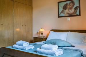 a bedroom with a bed with towels on it at Apartment Voula Myrtos in Anomeriá