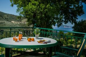 a table with oranges and glasses of juice on a balcony at Apartment Voula Myrtos in Anomeriá