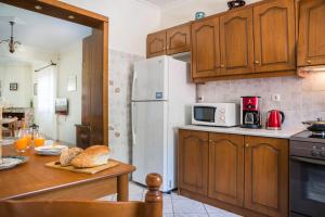 a kitchen with a white refrigerator and a table with bread at Apartment Voula Myrtos in Anomeriá