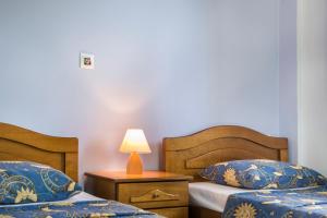 a bedroom with two beds and a lamp on a table at Apartment Voula Myrtos in Anomeriá