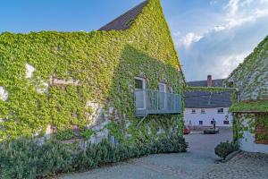 a building covered in ivy with a balcony at Pferdehof Berger in Penig