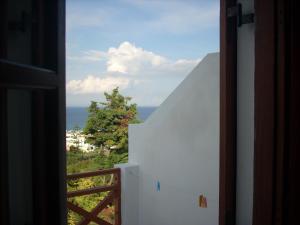 an open door to a balcony with a view of the ocean at Azolimnos Bay in Azolimnos