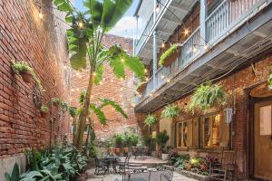 a courtyard with tables and plants in a brick building at French Quarter Mansion in New Orleans