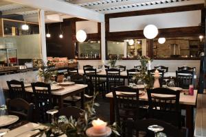 un comedor con mesas, sillas y luces en Culinary Boutique Hotel Kladi Elias, en Mesorópi