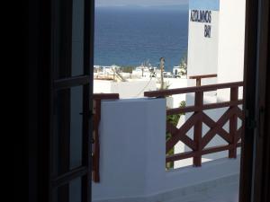 an open door to a balcony with the ocean in the background at Azolimnos Bay in Azolimnos Syros