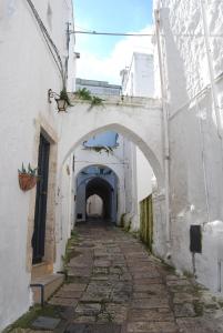 Une allée dans un vieux bâtiment avec une arche dans l'établissement I 7 Archi Guest House, à Ostuni