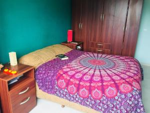 1 dormitorio con 1 cama con edredón morado en Departamento-Casa-Marcos en La Plata