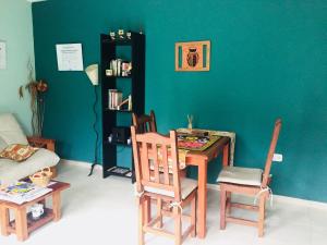 Habitación con mesa, sillas y pared verde. en Departamento-Casa-Marcos en La Plata