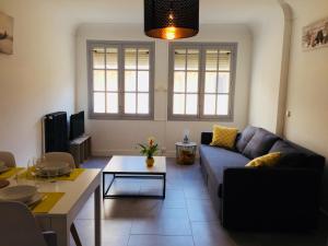 een woonkamer met een bank en een tafel bij La Maisonnette in Carcassonne