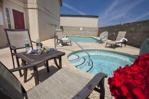 uma piscina com mesa, cadeiras e rosas em Granzella's Inn em Williams