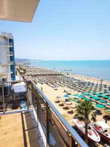 a beach with chairs and umbrellas and the ocean at Vila One Beach Hotel in Durrës