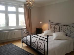 Schlafzimmer mit einem schwarzen Bett mit weißer Bettwäsche und Kissen in der Unterkunft Haus MeerZeit in Cuxhaven