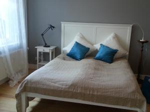 ein Schlafzimmer mit einem Bett mit blauen Kissen in der Unterkunft Haus MeerZeit in Cuxhaven