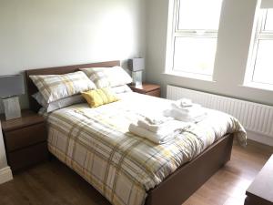 1 dormitorio con 1 cama con toallas en Mourne Walks B & B en Annalong