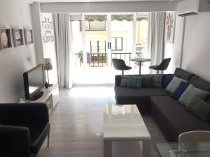 sala de estar con sofá y TV en Casa Centro en Benidorm