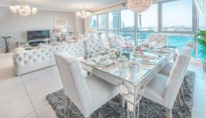 una sala da pranzo con tavolo in vetro e sedie bianche di Elite Royal Apartment - Full Burj Khalifa & Fountain View - Premium a Dubai