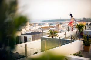 a woman in a dress on top of a building at Kook Hotel Tarifa in Tarifa