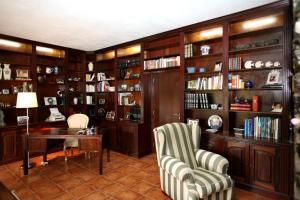 カスタニェイラ・デ・ペーラにあるCasa Ribeira de Peraの図書室(椅子2脚、テーブル、本棚付)