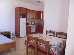 a kitchen with a table and a white refrigerator at Eugenia travasarou sea view appartments in Diakofti