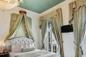 a bedroom with a canopy bed and a window at French Quarter Mansion in New Orleans