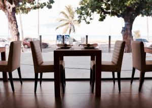 a table and chairs in a room with a window at Hotel do Mar Cabo Branco in João Pessoa